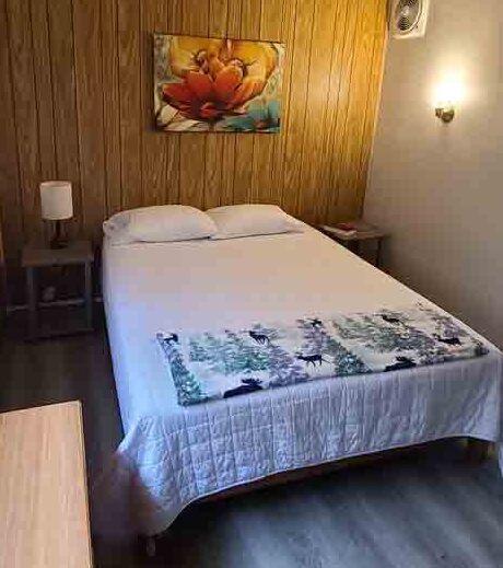 a bed sitting in a bedroom next to a wooden wall