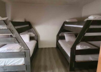 two bunk beds in a room with wood floors