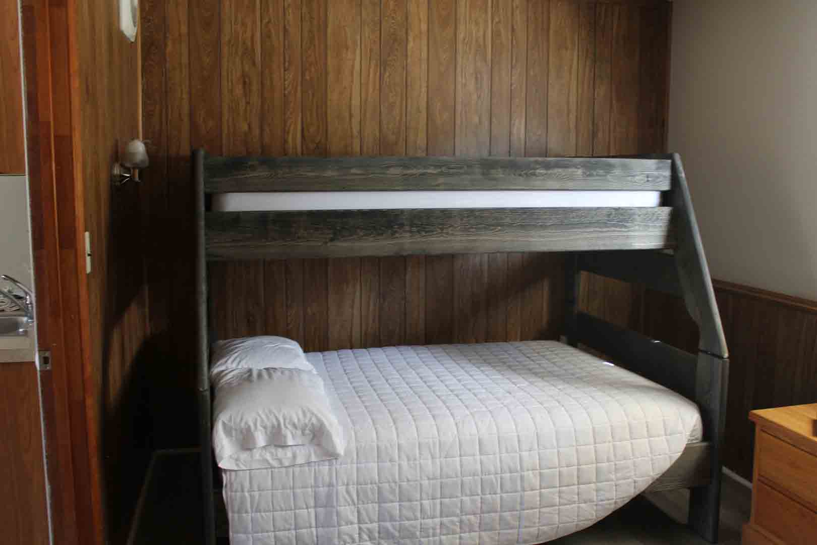 a bunk bed in a small room with wood paneling