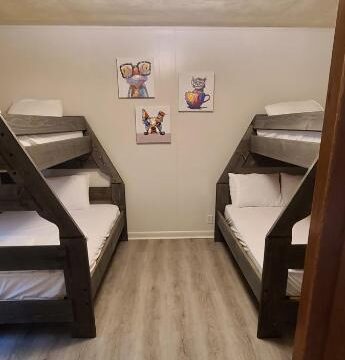 a room with bunk beds and wooden floors