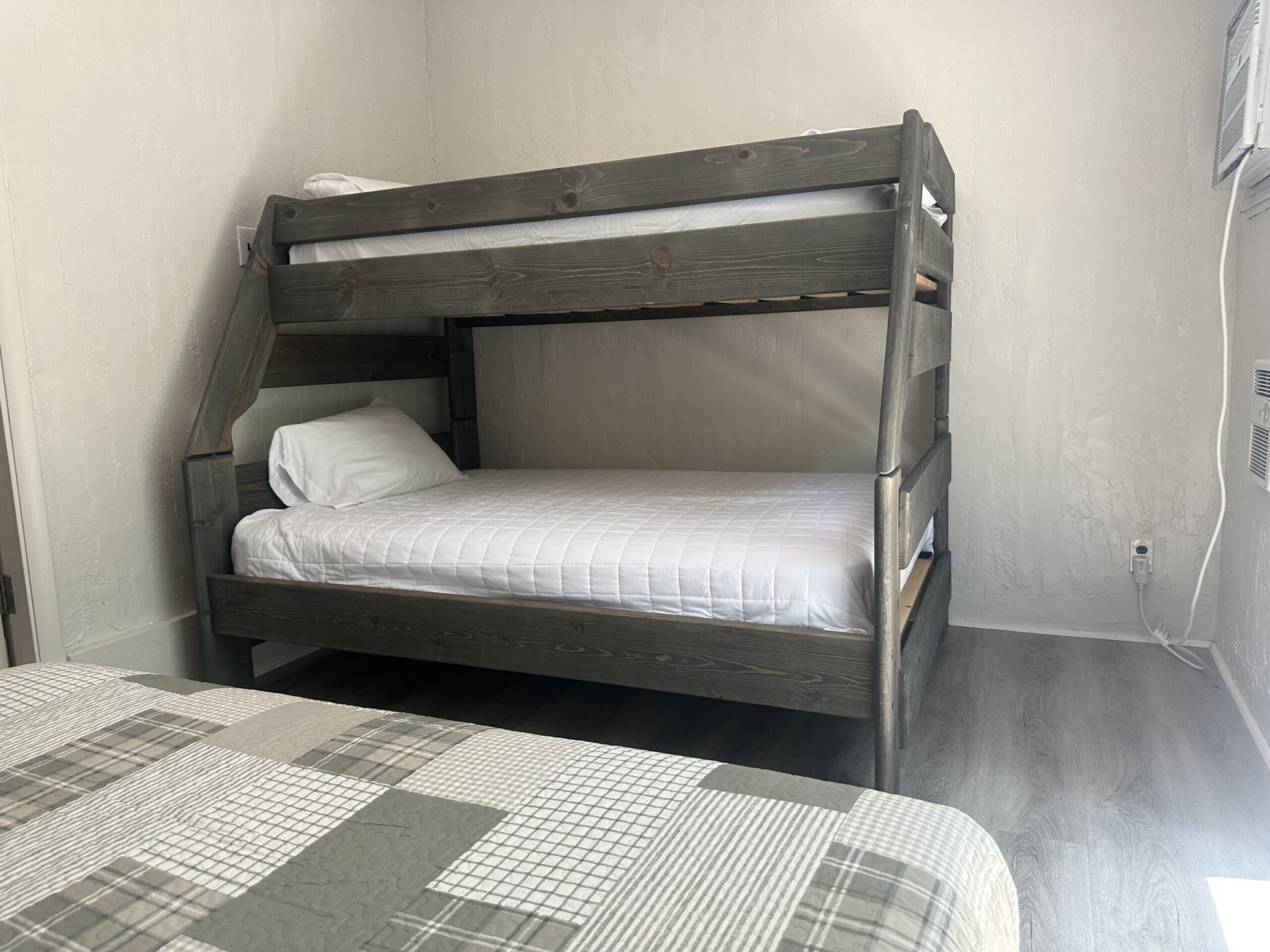 a bunk bed in a small room with a checkered bedspread