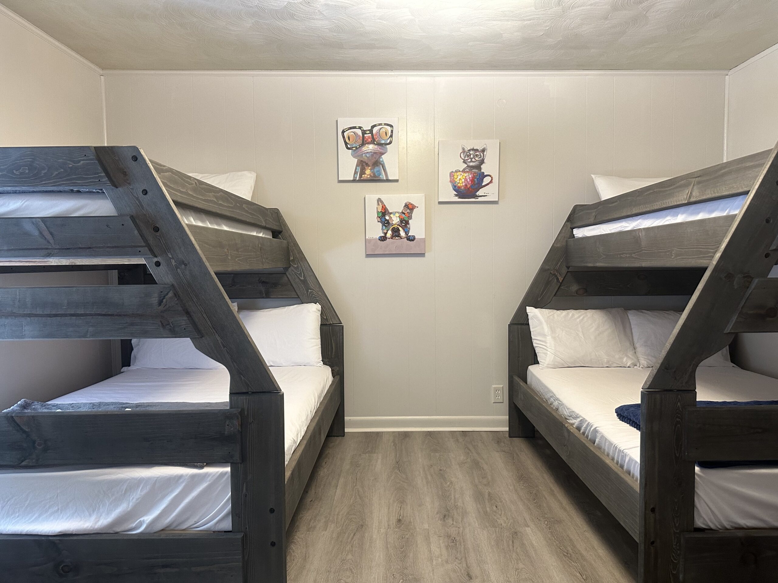 three bunk beds in a small room with wood flooring