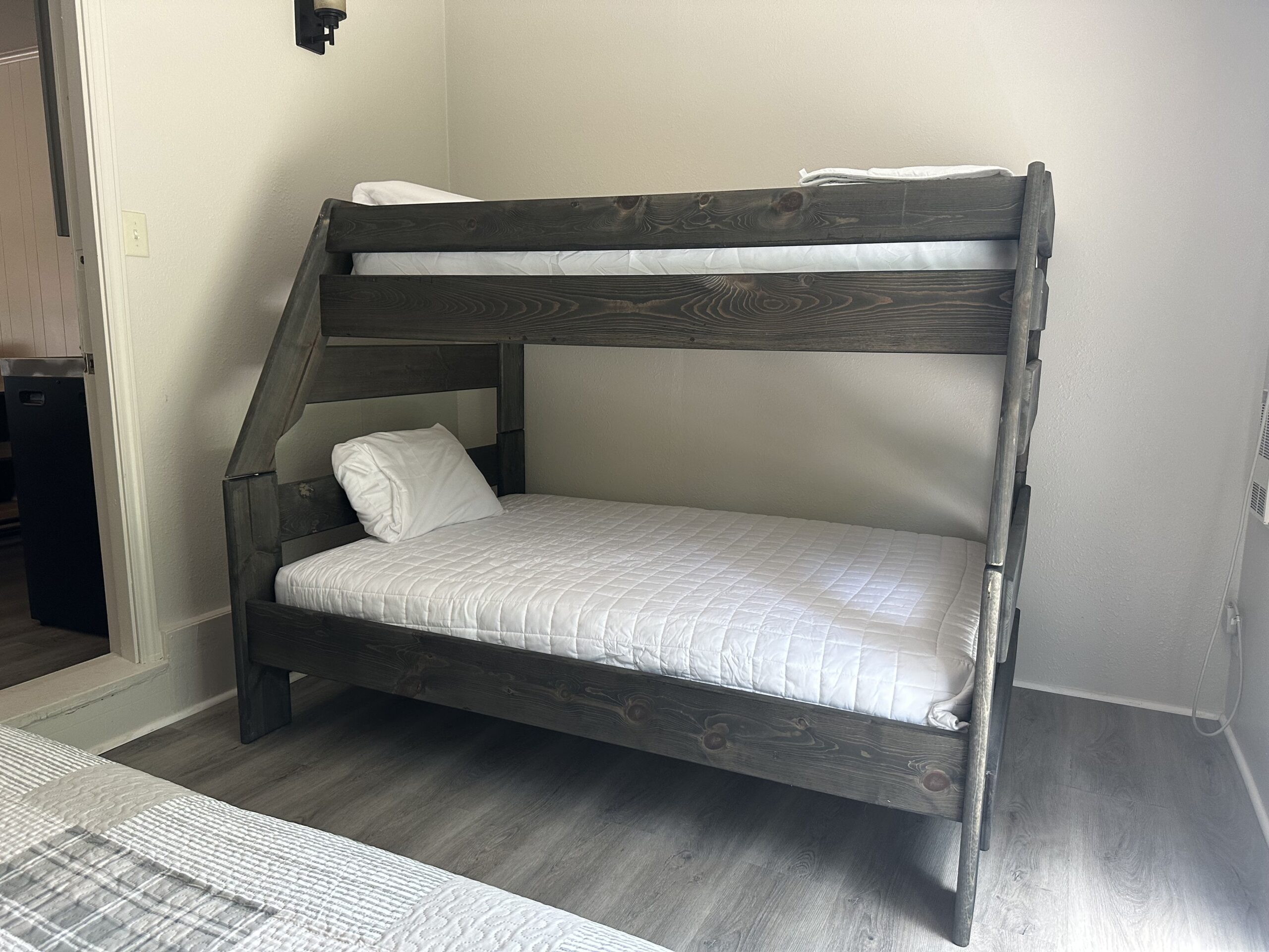 a bunk bed in a bedroom with white sheets