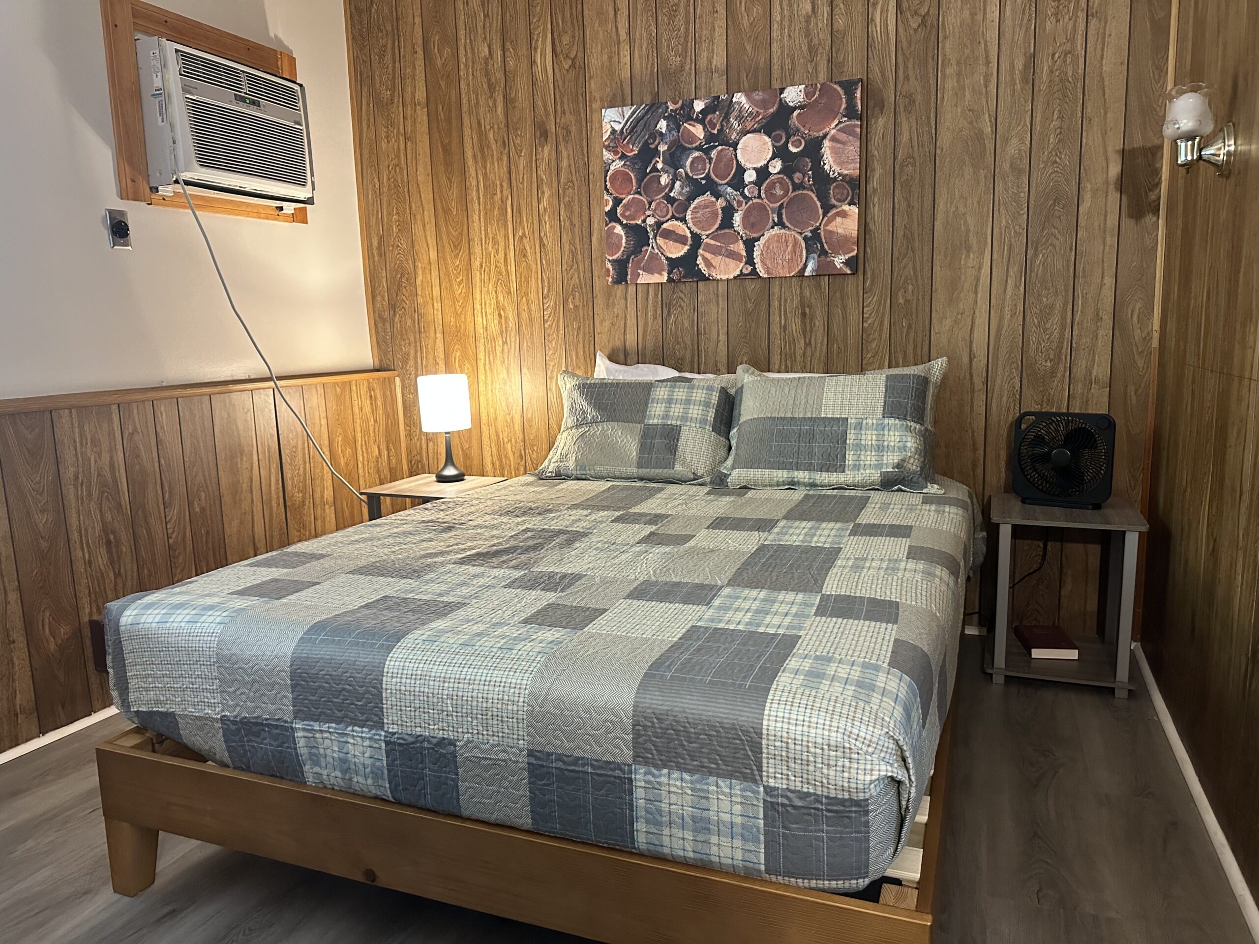 a bedroom with wood paneling and a bed