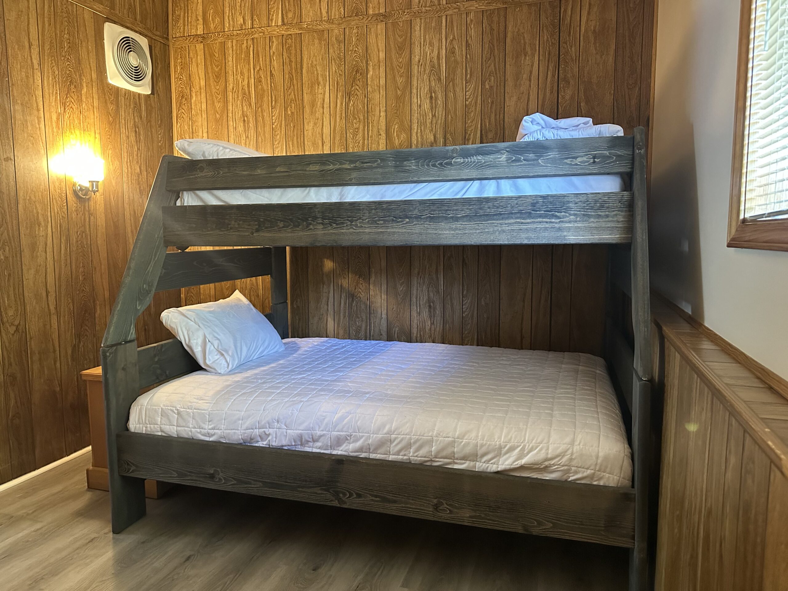 a bunk bed in a room with wood paneling