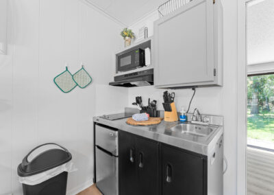 a kitchen with a sink, microwave, and trash can