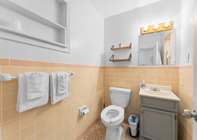 a bathroom with a toilet, sink, and mirror