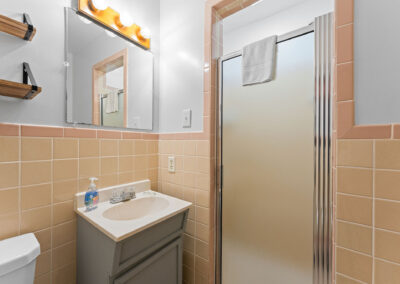 a bathroom with a toilet, sink and mirror