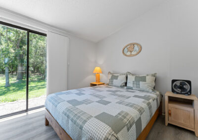 a bed room with a neatly made bed and a sliding glass door