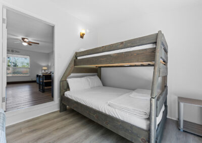 a bedroom with a bunk bed and hardwood floors