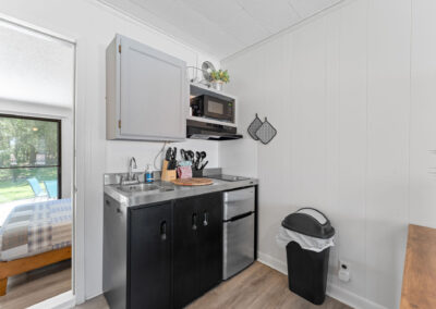 a kitchen area with a sink, microwave and a window