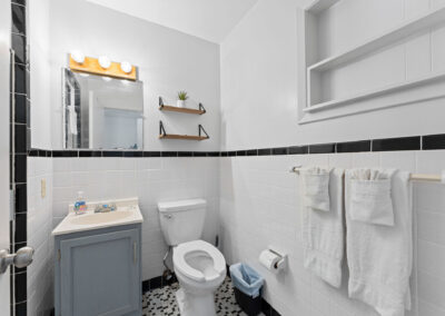 a bathroom with a toilet, sink, and mirror