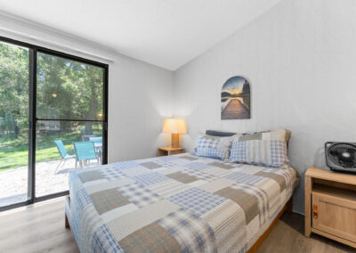 a bedroom with a large bed and a sliding glass door