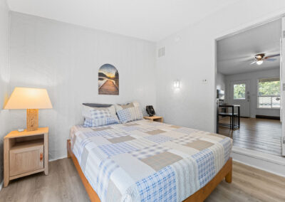 a bedroom with a bed, nightstand, and mirror