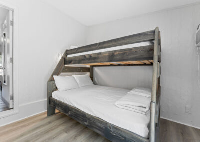 a bedroom with a bunk bed and a mirror