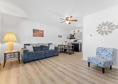 a living room filled with furniture and a ceiling fan