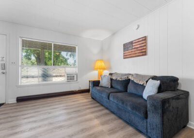 a living room with white walls and a blue couch