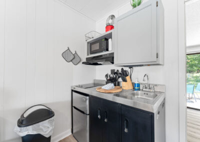 a kitchen with a sink, microwave, and a trash can