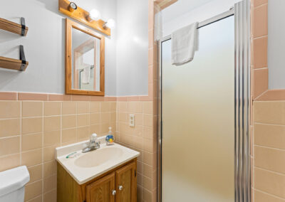 a bathroom with a toilet, sink, and shower stall