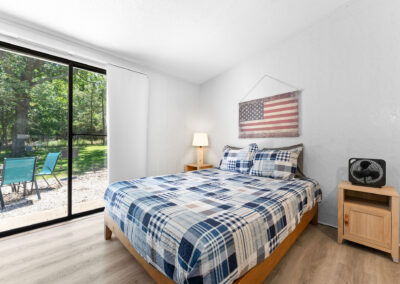 a bedroom with a large bed and a sliding glass door