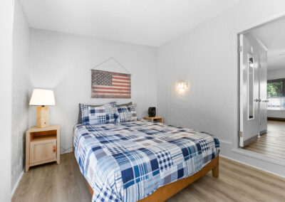 a bedroom with a bed, nightstand, and american flag on the wall