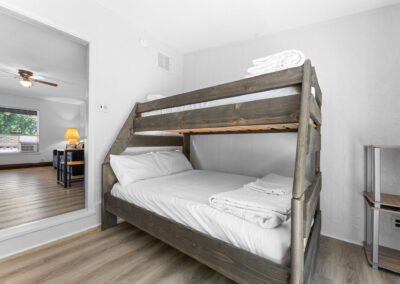 a bedroom with a bunk bed and hardwood floors