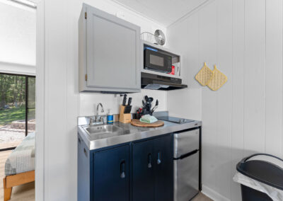 a kitchen area with a sink, microwave and a window