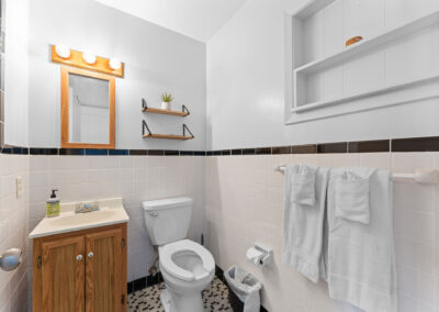 a bathroom with a toilet, sink, and mirror