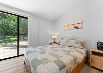a bedroom with a large bed and a sliding glass door