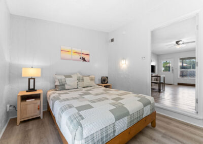 a bedroom with a bed, nightstand, and mirror