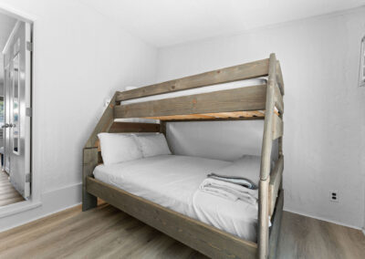 a bedroom with a bunk bed and a mirror