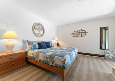 a bedroom with a bed, dresser, and mirror