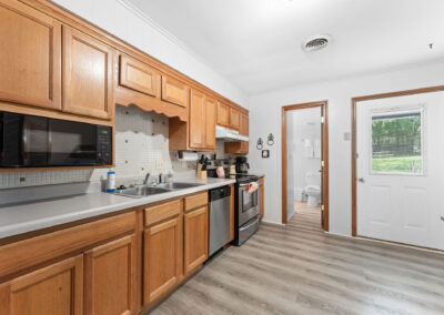 a kitchen with wooden cabinets and white walls
