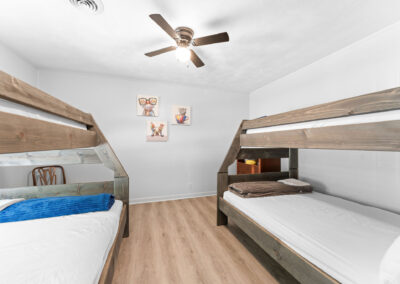 a bedroom with bunk beds and a ceiling fan
