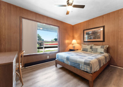 a bedroom with wood paneling and a bed