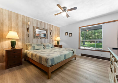 a bedroom with a bed, dresser, and ceiling fan