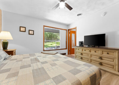 a bedroom with a large bed and a flat screen tv