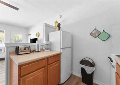 a kitchen with a white refrigerator freezer next to a window