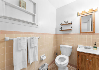 a bathroom with a toilet, sink and mirror