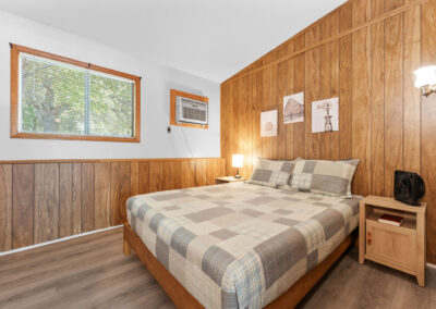 a bed room with a neatly made bed and a window