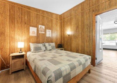 a bedroom with wood paneling and a bed