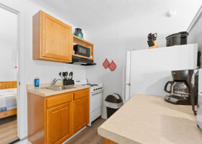 a kitchen with a refrigerator, stove, microwave and sink