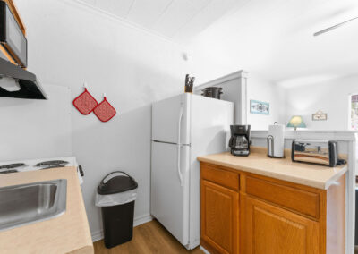 a kitchen with a sink, refrigerator, microwave, and toaster oven