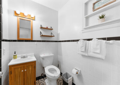 a bathroom with a toilet, sink, and mirror