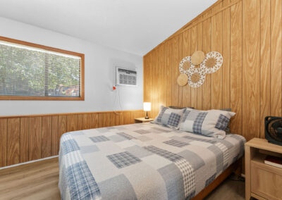 a bedroom with wood paneling and a bed