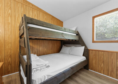 a bunk bed in a small room with wood paneling