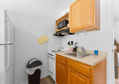 a kitchen with a sink, stove, refrigerator and microwave