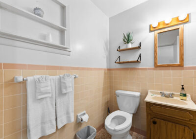 a bathroom with a sink, toilet, and mirror