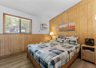 a bedroom with wood paneling and a bed
