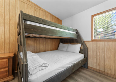 a bunk bed in a room with wood paneling